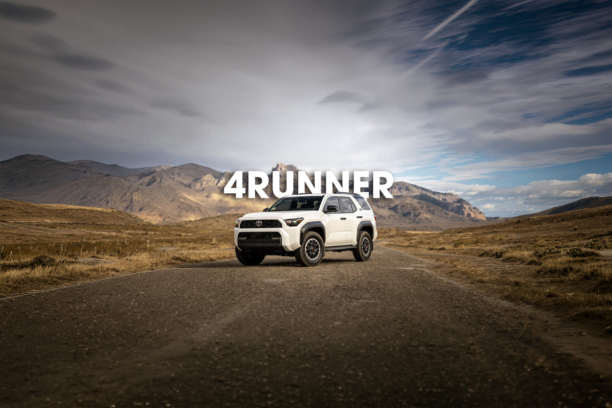 White Toyota 4Runner on a gravel road with mountains