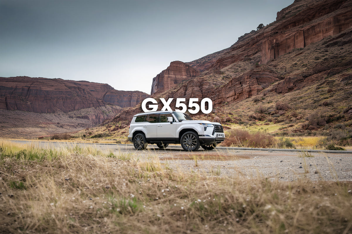 White Lexus GX 550 below red rock cliffs