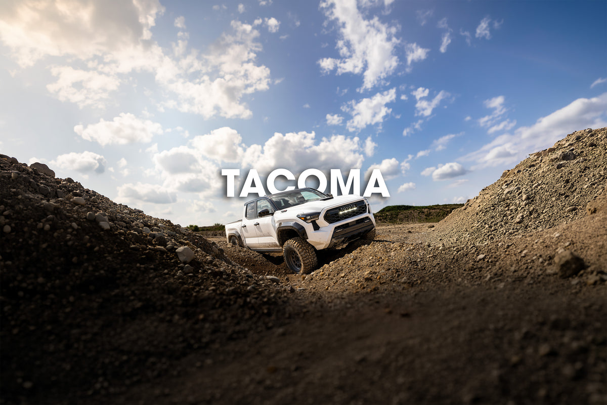 White Toyota Tacoma climbing through a gravel pit